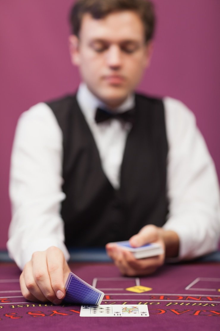 Dealer casino live sedang membagikan kartu dengan latar belakang mewah